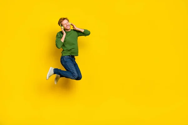 Full längd foto av cool drömsk kille klädd tröja hörlurar njuter musik tomt utrymme isolerad gul färg bakgrund — Stockfoto