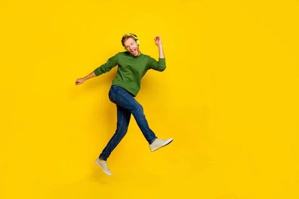 Foto de cuerpo entero de chico divertido de ensueño vestido suéter auriculares disfrutando de la música bailando espacio vacío aislado color amarillo fondo —  Fotos de Stock