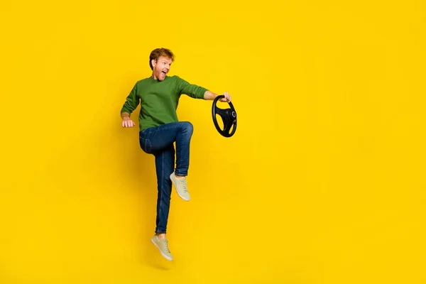 Foto de longitud completa de chico divertido impresionado vestido suéter conducción vehículo vacío espacio aislado color amarillo fondo — Foto de Stock