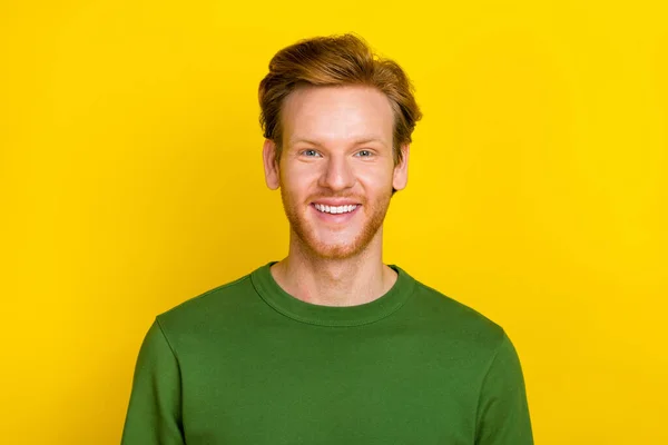 Foto de atractivo joven encantador vestido suéter verde sonriendo aislado color amarillo fondo — Foto de Stock