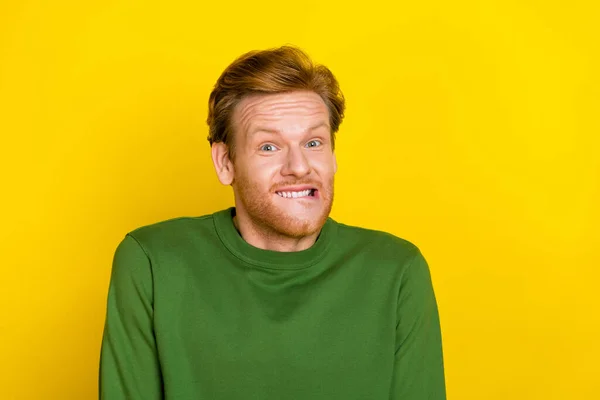 Foto van lastige grappige man dragen groene trui bijten lip lege ruimte geïsoleerde gele kleur achtergrond — Stockfoto