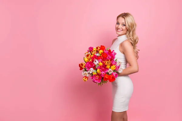 Foto de sexy adorable dama vestida traje de glamour presentando grandes tulipanes ramo vacío espacio aislado color rosa fondo — Foto de Stock