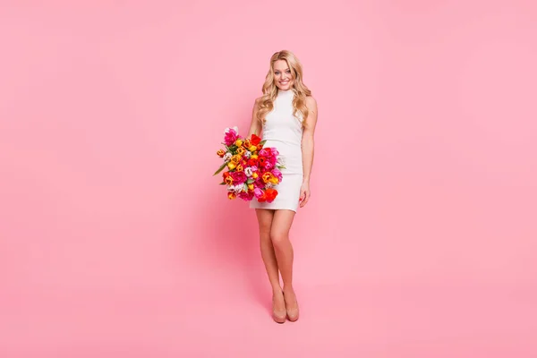 Foto de mujer de buen humor positivo usar vestido blanco sosteniendo flores ramo aislado color rosa fondo — Foto de Stock