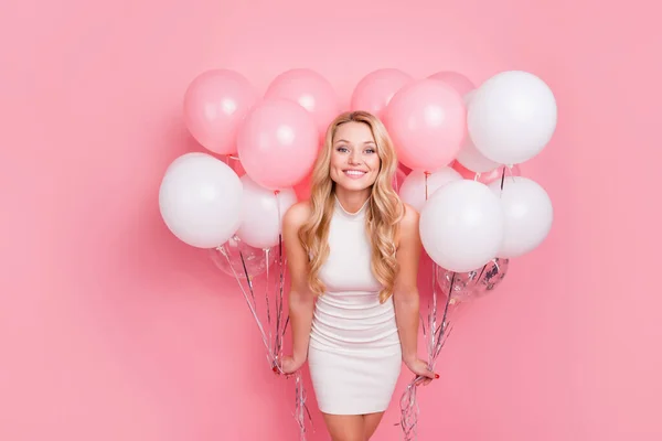 Foto de adorable mujer divertida usar vestido blanco sonriendo sosteniendo muchos globos aislados de color rosa de fondo —  Fotos de Stock