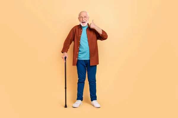 Teljes hosszúságú kép boldog nyugdíjas megy sétálni ajánljuk az aktív egészséges életmód elszigetelt bézs színű háttér — Stock Fotó