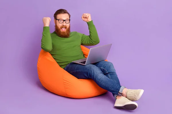 Bilder i full størrelse av en forbløffet mann med sittepose opp knyttnever feirer bragd isolert på fiolett bakgrunn – stockfoto
