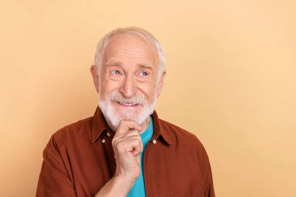 Fotografie pěkný starší bílý účes muž vypadat prázdný prostor nosit hnědou košili izolované na béžové barvy pozadí — Stock fotografie