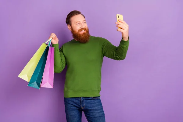 Фото красивого позитивного чоловіка роблять потокове відео в блозі під час покупки ізольовано на фіолетовому кольоровому фоні — стокове фото