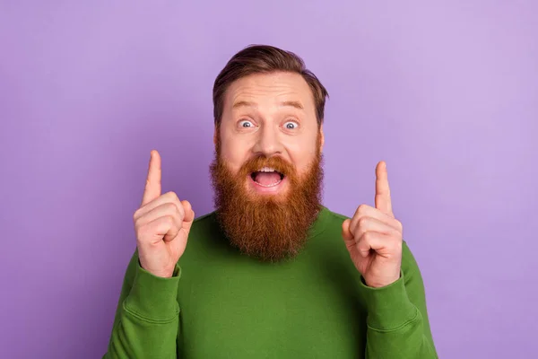 Portrét atraktivní veselý vtipný chlap ukazuje ukazováčky nahoru kopírovat prostor pro reklamu nápad izolované přes světlé fialové fialové barvy pozadí — Stock fotografie