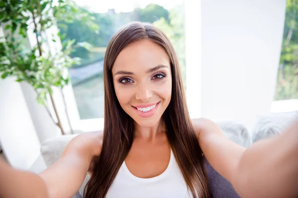 Portrait of positive pretty lovely lady make selfie enjoy talking blog followers in modern light living room hotel
