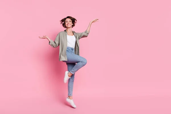 Full length photo of young cheerful lady have fun jump ads advantage recommend isolated over pink color background — Stock Photo, Image