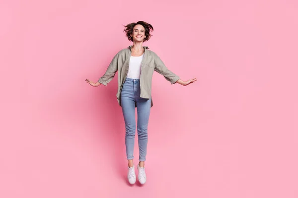 Pełny rozmiar zdjęcie podekscytowany szalony dziewczyna skoków zębaty uśmiech spędzić rozrywkę izolowane na różowy kolor tła — Zdjęcie stockowe