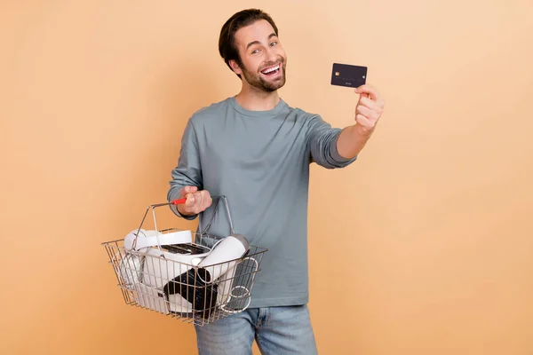 Foto van de jongeman maken winkelen consument bankkaart zwart vrijdag voordeel geïsoleerd over beige kleur achtergrond — Stockfoto