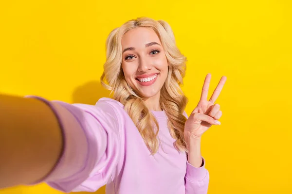 Foto de chica adorable positiva hacer dedos de la mano selfie hacer v-signo aislado en el fondo de color amarillo —  Fotos de Stock
