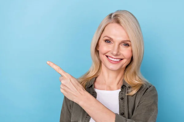 Retrato de la señora de mediana edad positiva dedo dedo vacío espacio presente anuncios promocionales aislado fondo de color pastel azul — Foto de Stock