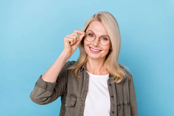 Ritratto di donna imprenditrice positiva di mezza età toccare il suo nuovo ottico specifiche isolato blu pastello colore sfondo — Foto Stock