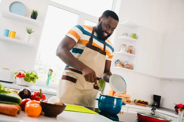 Портрет веселої молодої людини насолоджується приготуванням свіжого овочевого супу вільного часу на кухні в приміщенні — стокове фото