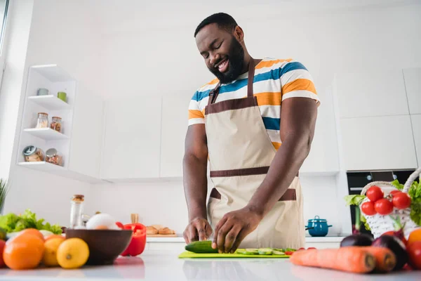 Портрет задоволеної позитивної людини тримає ніж для різання свіжої огіркової дошки кухонного будинку в приміщенні — стокове фото