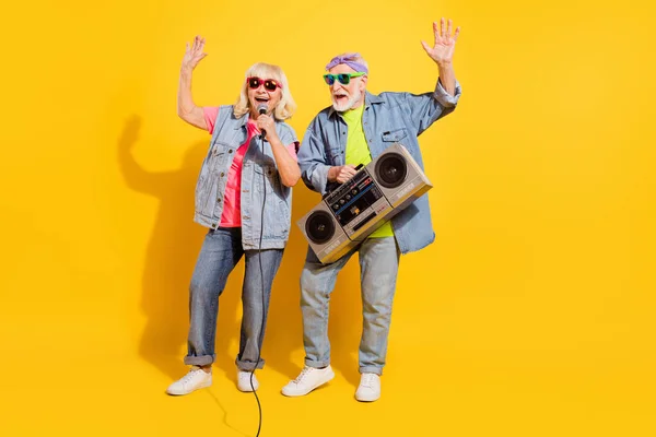 Foto van opgewonden mooie echtgenoot vrouw dragen jeans shirts zingen luisteren boombox geïsoleerde gele kleur achtergrond — Stockfoto