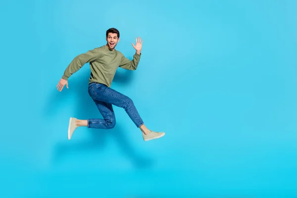 Full body foto van tevreden blij jong persoon genieten van hardlopen springen geïsoleerd op blauwe kleur achtergrond — Stockfoto