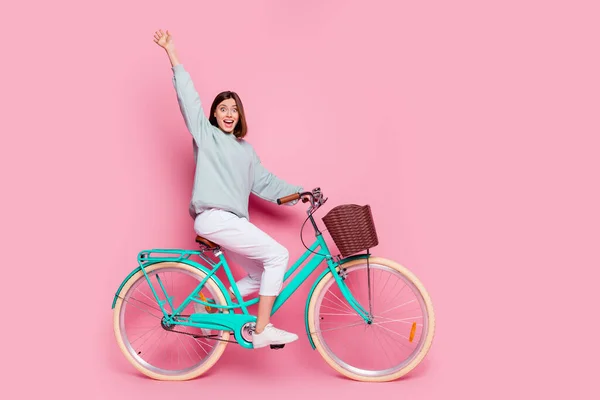 Perfil de corpo inteiro foto lateral da jovem mulher bonita bom humor andar de bicicleta tempo livre isolado sobre fundo cor-de-rosa — Fotografia de Stock