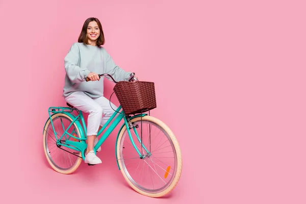 Pełna długość profil boczne zdjęcie młodej dziewczyny jeździć rower weekend izolowany na różowy kolor tła — Zdjęcie stockowe