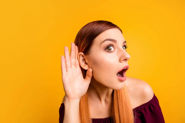 Foto de engraçado animado jovem senhora vestida vermelho roupas braço orelha ouvindo você isolado cor amarela fundo — Fotografia de Stock