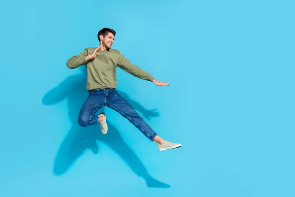 Retrato em tamanho completo de esportivo animado pessoa saltar ar batalha mãos pernas pontapé isolado no fundo de cor azul — Fotografia de Stock
