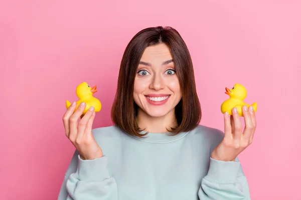 Foto de la juventud alegre bonita dama buen humor jugar pequeño pato amarillo aislado sobre fondo de color rosa —  Fotos de Stock