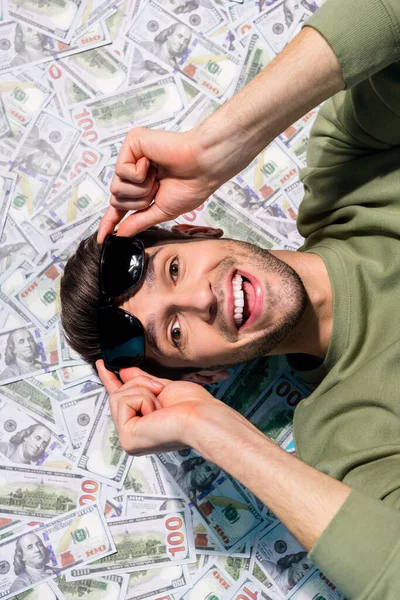 Above view vertical photo of astonished positive man touch glasses isolated on money background — Stock Photo, Image