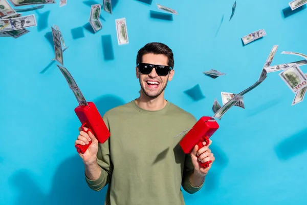 Foto de brunet impresionado millennial chico disparar dinero usar gafas camisa gris aislado sobre fondo de color azul — Foto de Stock