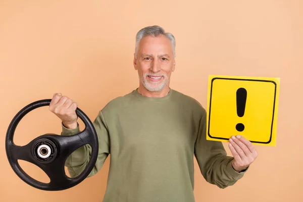 Foto van volwassen man houden stuurwiel teken pas op weg dienst voertuig geïsoleerd over beige kleur achtergrond — Stockfoto