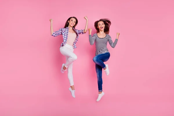 Фотографія повного розміру двох спортивних енергійних людей, які стрибають підняти кулаки ізольовані на фоні рожевого кольору — стокове фото