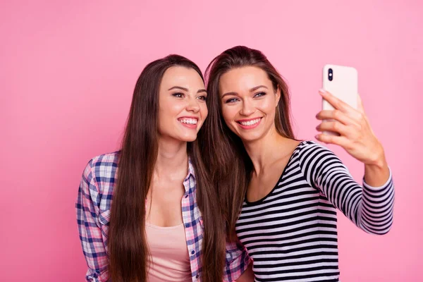 Retrato de dos encantadoras chicas agradables hacen selfie grabación de vídeo aislado en el fondo de color rosa —  Fotos de Stock