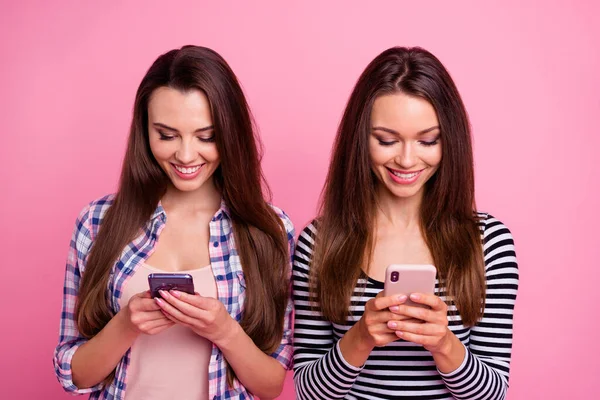 写真2かなり陽気な女性ホールド使用電話書き込み入力ポストコメントピンクの色の背景に隔離 — ストック写真
