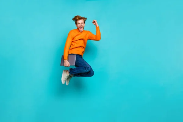 Foto de longitud completa de chico afortunado emocionado vestido suéter naranja celebración de gadget moderno espacio vacío aislado color turquesa fondo —  Fotos de Stock