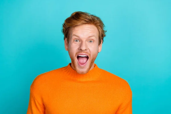Foto van aantrekkelijke onder de indruk jongen gekleed oranje trui open mond geïsoleerde turquoise kleur achtergrond — Stockfoto