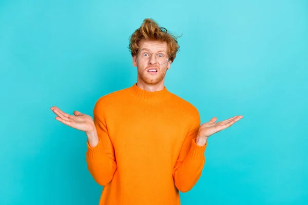 Foto av roliga tveksam ung man bär orange pullover glasögon ryckande axlar isolerad teal färg bakgrund — Stockfoto