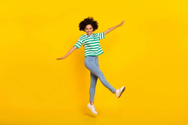 Foto de corpo inteiro do funky millennial senhora salto desgaste t-shirt calça jeans isolado no fundo de cor amarela — Fotografia de Stock