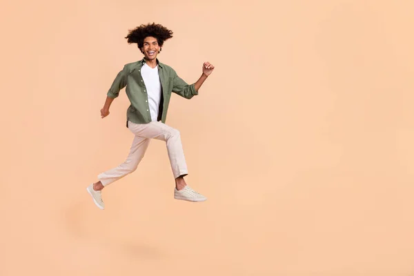 Longitud completa cuerpo tamaño vista de atractivo alegre chico saltando corriendo gran éxito aislado en beige pastel color fondo —  Fotos de Stock