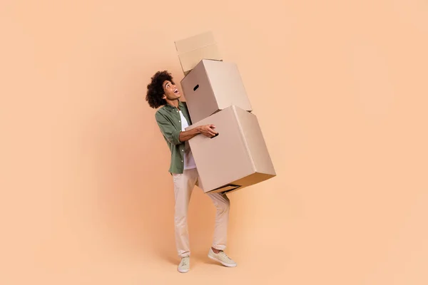 全身サイズビューの魅力的な陽気な波状毛の男のオフィスボックスを運ぶベージュパステルカラーの背景に孤立 — ストック写真