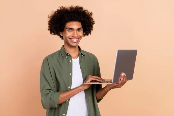 Portrét atraktivní veselý zkušený vlnitý chlap agent makléř pomocí notebooku vyvíjející izolované nad béžové pastelové barvy pozadí — Stock fotografie
