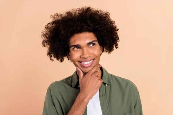 Ritratto di attraente sconcertato allegro ragazzo dai capelli ondulati toccando mento brainstorming isolato su sfondo di colore pastello beige — Foto Stock