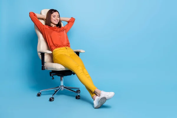 Tamanho do corpo de comprimento total vista de menina sonhadora alegre atraente descansando em poltrona de escritório isolado sobre fundo de cor azul brilhante — Fotografia de Stock