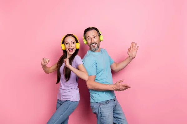 Foto de duas pessoas loucas animadas gostam de ouvir música favorita dançando isolada no fundo da cor rosa — Fotografia de Stock