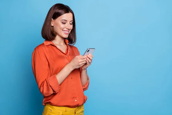 Portret van aantrekkelijke vrolijke gericht meisje met behulp van apparaat kopiëren ruimte advertentie geïsoleerd over helder blauwe kleur achtergrond — Stockfoto