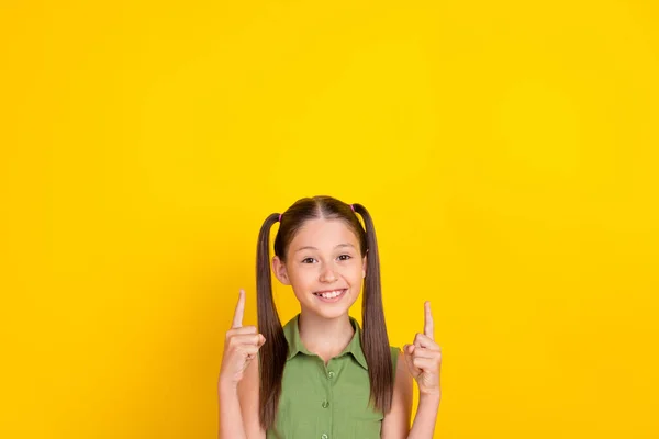 Foto von funky kleine Schwänze Frisur Mädchen zeigen leeren Raum tragen grünes Top isoliert auf gelbem Hintergrund — Stockfoto