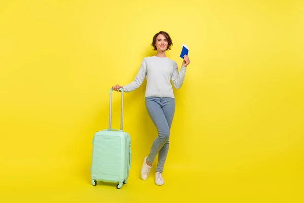 正面的游客女士持票袋穿着蓝色毛衣牛仔裤鞋黄褐色底色孤立的照片 — 图库照片