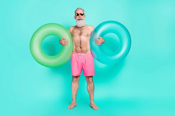 Foto Bekymmerslös Senior Man Hålla Två Uppblåsbara Cirklar Bära Solglasögon — Stockfoto