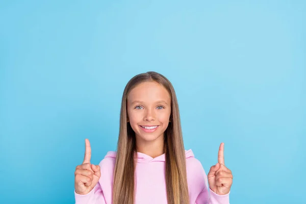 明るい幸せな若い女の子のポイント指アップ空のスペースソリューションニューストレンディーな青の色の背景に孤立 — ストック写真